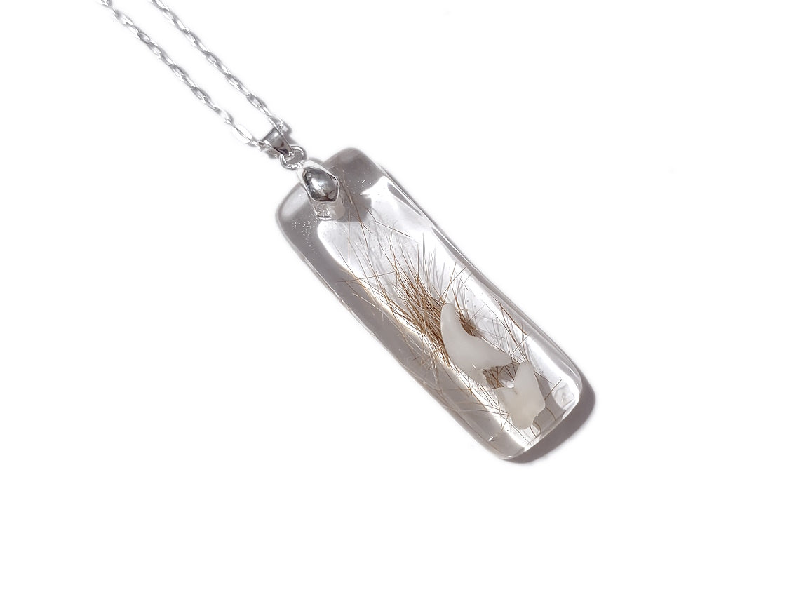 Handmade memorial pendant containing pet fur and baby teeth