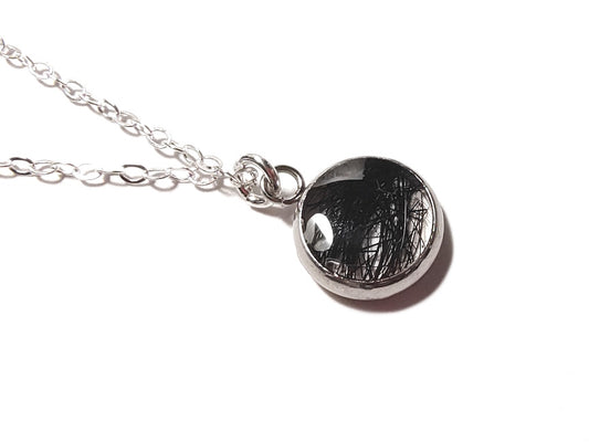 A pet memorial pendant on silver chain.