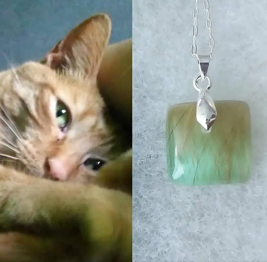 A square memorial necklace with cat fur, custom matched to the cat's eye color.