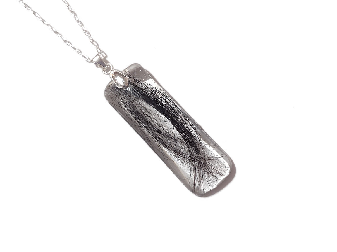 A bar shaped memorial necklace with loved ones hair