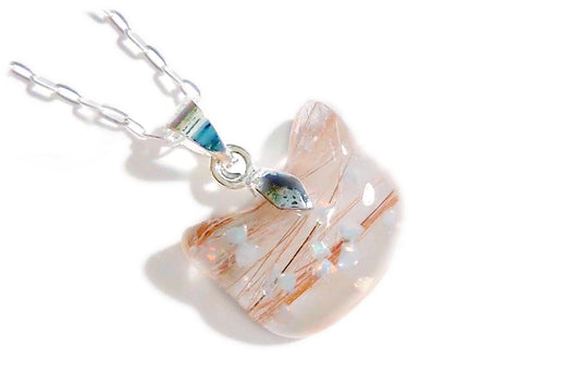 A cat keepsake necklace with fur and crushed opal