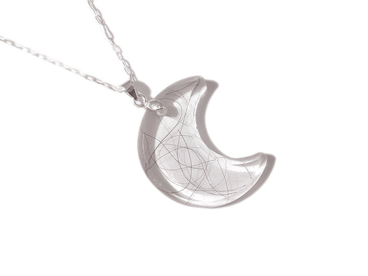 A handmade memorial moon necklace with a loved ones hair, fur, or ashes.
