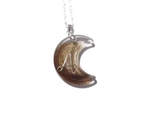 A keepsake moon pendant with loved ones hair and the initial A