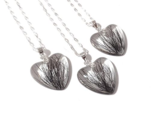 Another view of a trio of small heart shaped keepsake necklaces