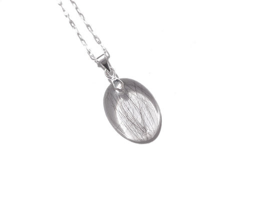 a small oval memorial necklace with a slight amount of hair
