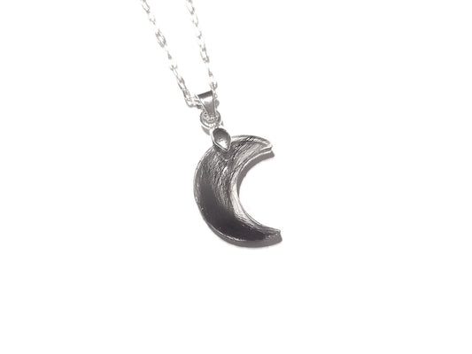 A tiny moon shaped memorial necklace with loved ones hair or fur
