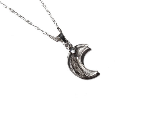A custom tiny moon memorial necklace with hair