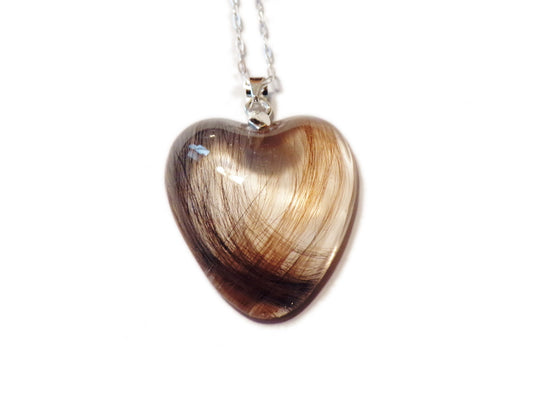 A handmade keepsake necklace in the heart shape with a loved ones hair, fur, or ashes.