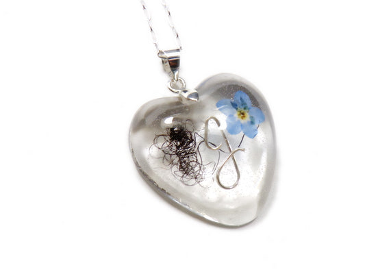 A handmade keepsake necklace in the heart shape with a loved ones hair, fur, or ashes.