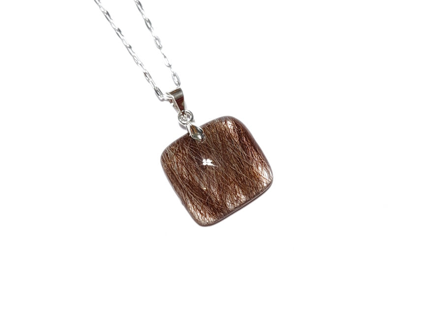 A small square pet memorial necklace containing hair, on a silver chain.