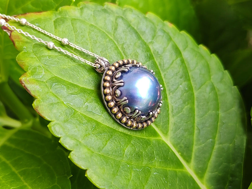 Pendant with blue pearl on a green leaf