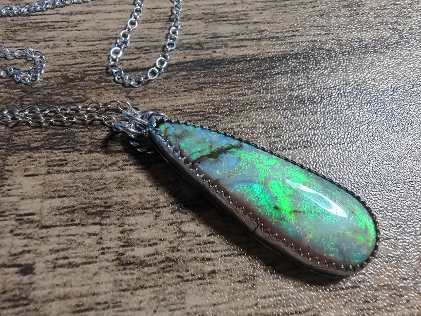 Opal pendant necklace on a wooden surface