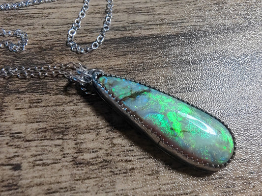 Opal pendant necklace on a wooden surface