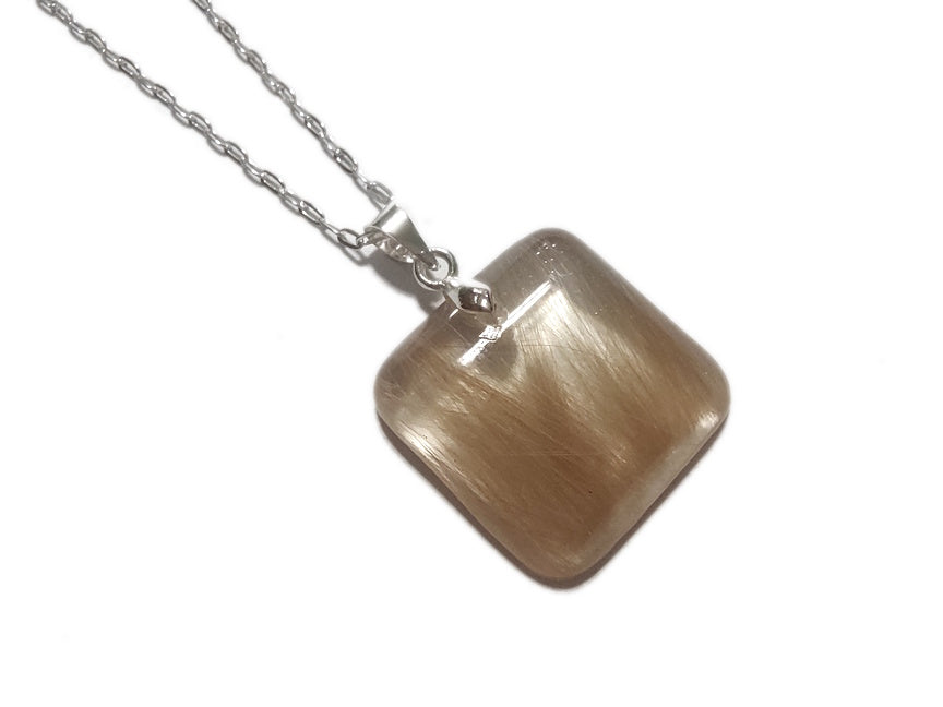 A small square pet memorial necklace containing hair, on a silver chain.