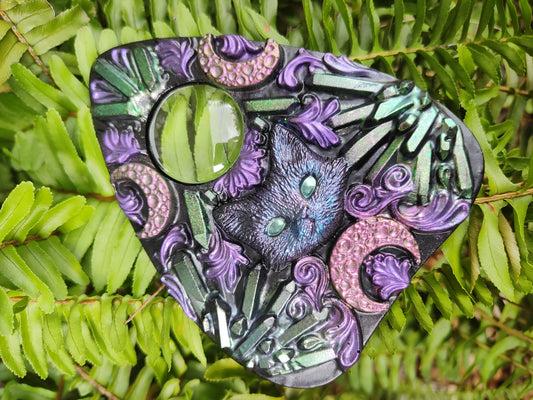 A highly detailed resin planchette with crystal and cat designs