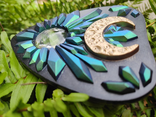 Decorative planchette with blueto green crystal design and gold crescent moon on green leaves