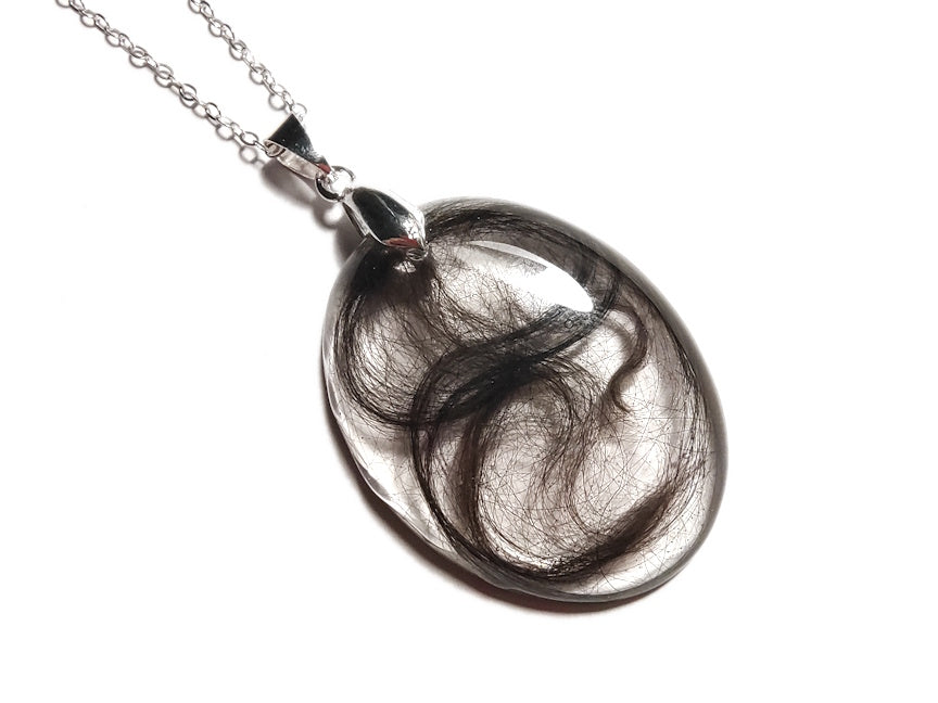 Hair locket keepsake necklace on silver chain.