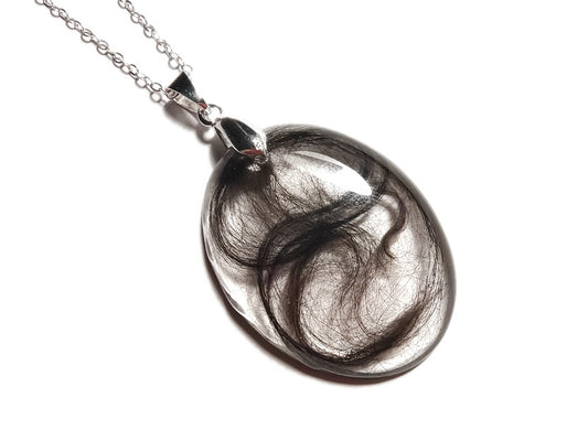 Hair locket keepsake necklace on silver chain.