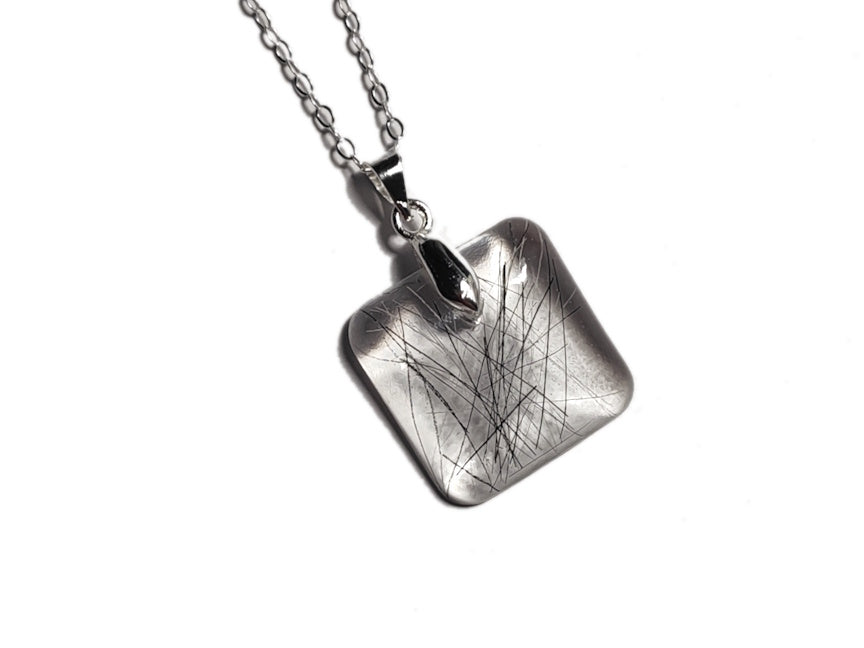 A pet memorial necklace with a small amount of hair.