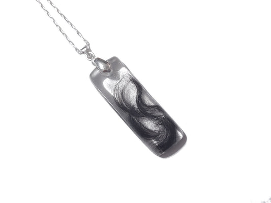 A bar shaped memorial necklace with loved ones hair