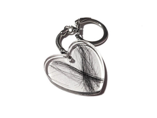 A large flat heart shaped keychain with a loved ones hair