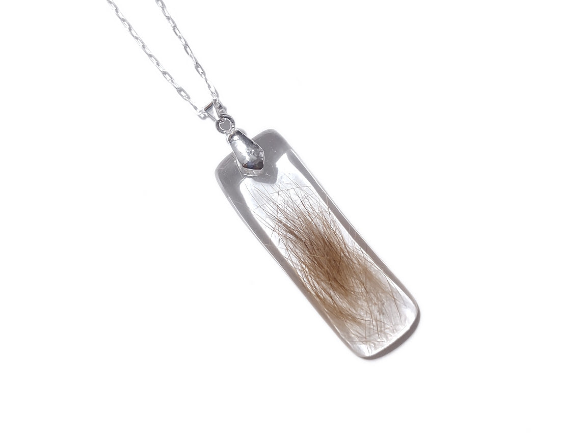 Handmade memorial pendant containing hair lock.