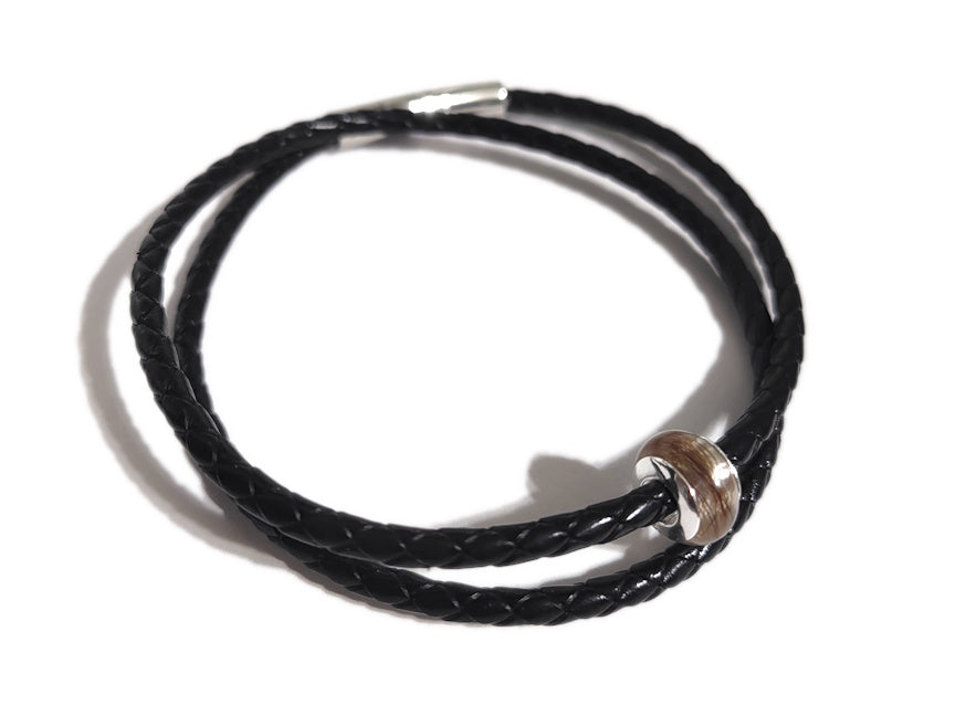Handmade memorial bead with hair and silver rivets on black braided leather bracelet