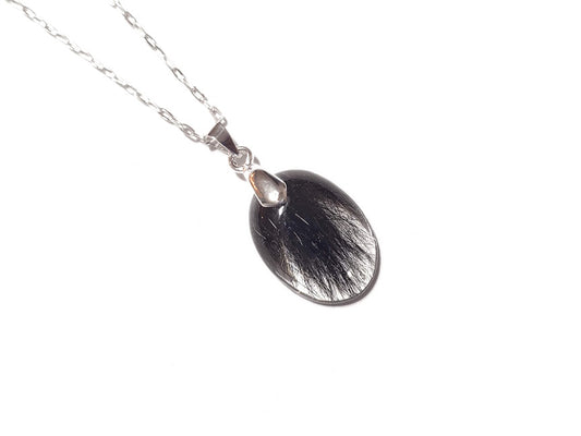 A small oval shaped memorial necklace with loved ones hair