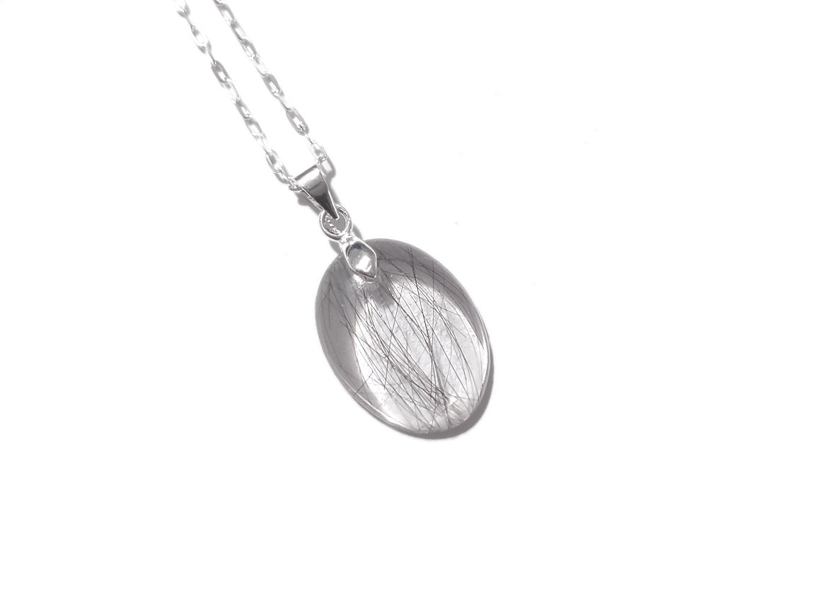 a small oval memorial necklace with a scant amount of hair
