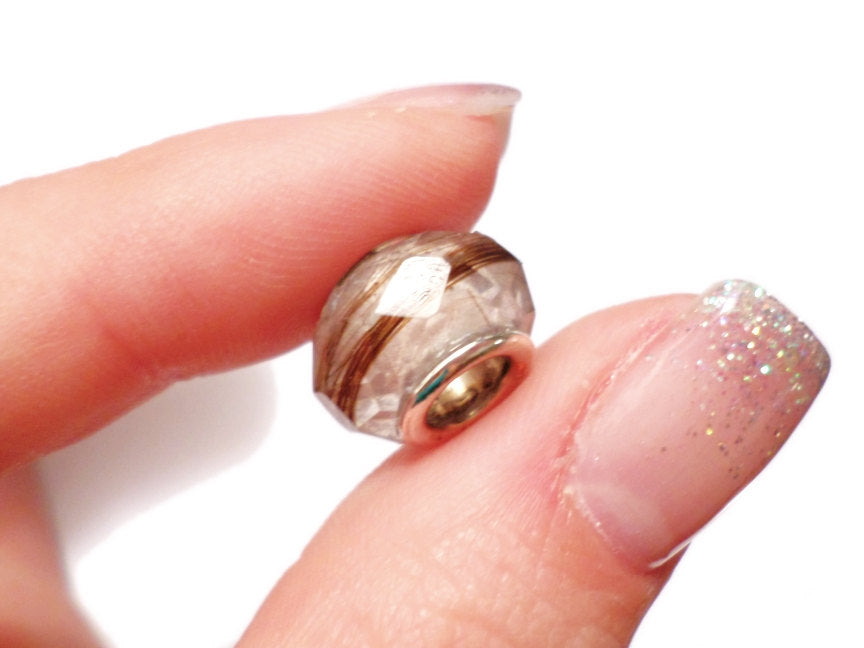 A close up of a faceted keepsake bead
